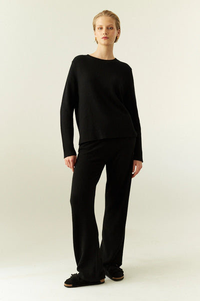Person wearing a black outfit on a white background