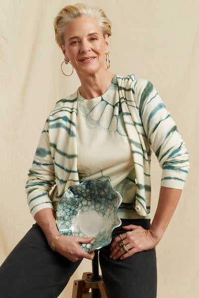 Woman holding a decorative plate against a beige background