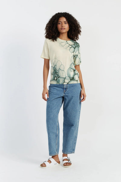 Woman wearing a floral t-shirt and blue jeans on a white background