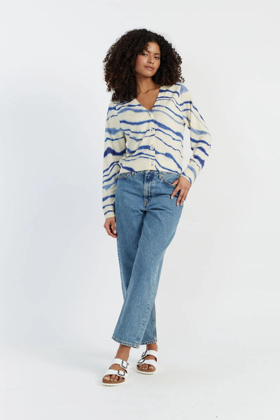 Woman wearing a striped sweater and blue jeans on a white background