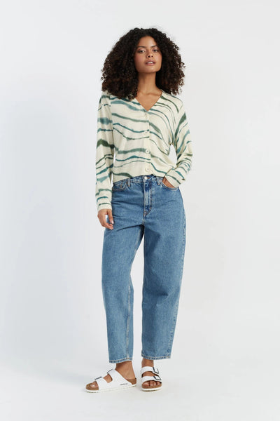 Woman wearing a striped sweater and blue jeans on a white background