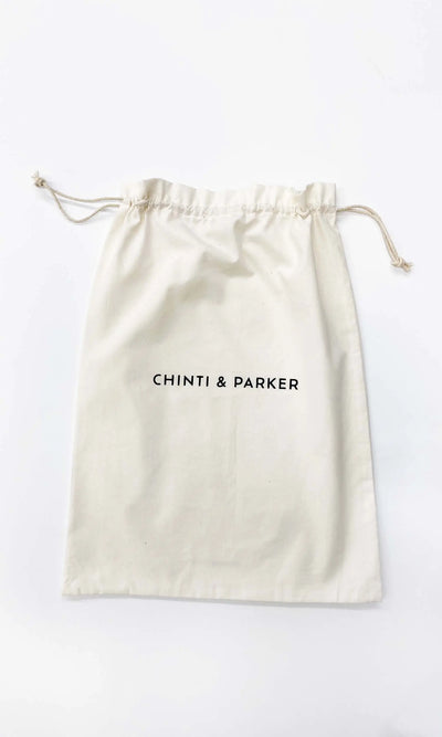 Beige drawstring bag with 'Chinti & Parker' branding on a white background