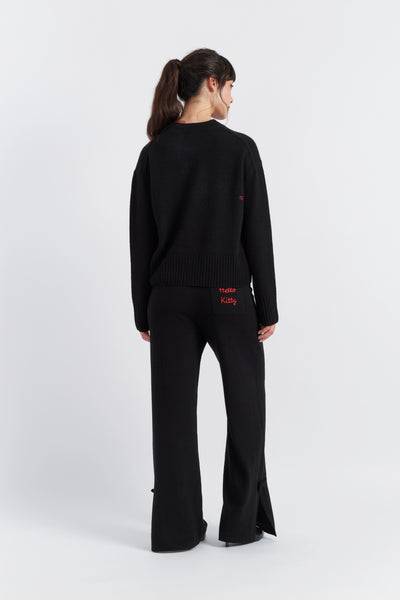 Person wearing a black outfit with red text on a white background