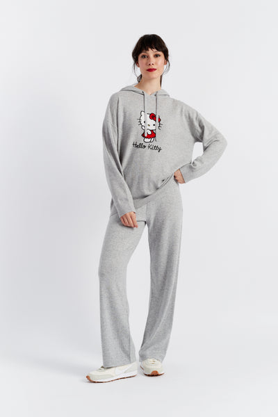 Person wearing gray 'Hello Kitty' pajama set on a white background