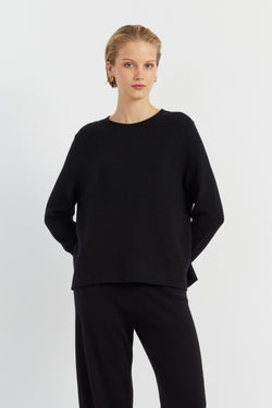Woman wearing a black outfit on a white background