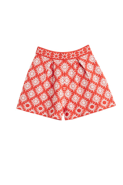 Red shorts with white floral pattern on a white background