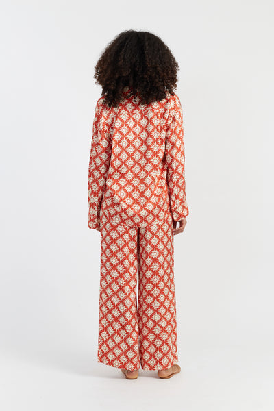 Person wearing a red and white patterned outfit on a white background