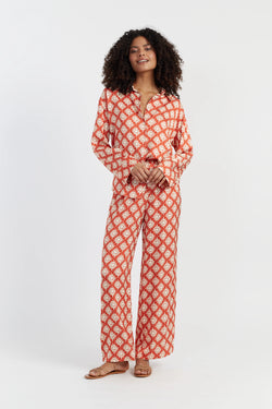 Woman wearing a red and white patterned outfit on a white background