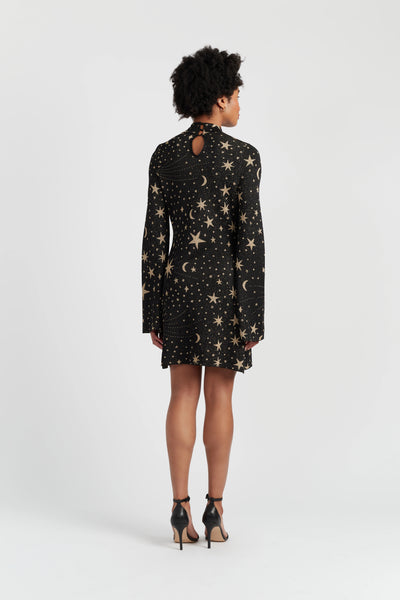 Woman wearing a black dress with star pattern on a white background
