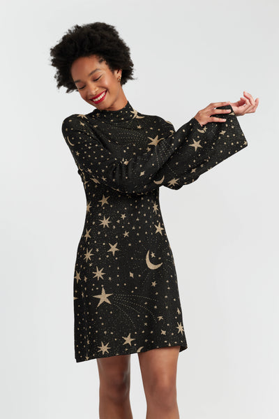 Woman wearing a black dress with star and moon patterns on a white background