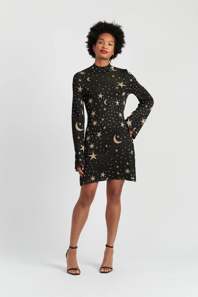 Woman wearing a black dress with star and moon patterns on a white background