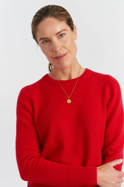 Woman wearing a red sweater against a white background