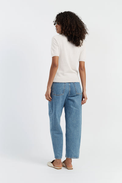 Person wearing a white shirt and blue jeans on a white background