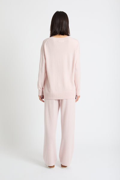 Person wearing a light pink pajama set on a white background