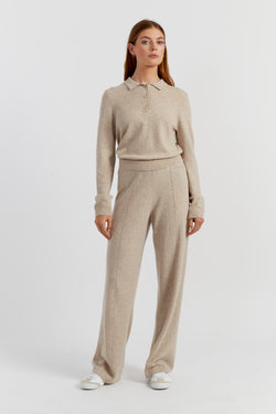 Woman wearing a beige long-sleeve polo shirt and matching pants on a white background