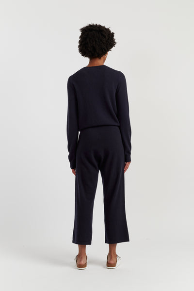 Person wearing a navy outfit on a white background