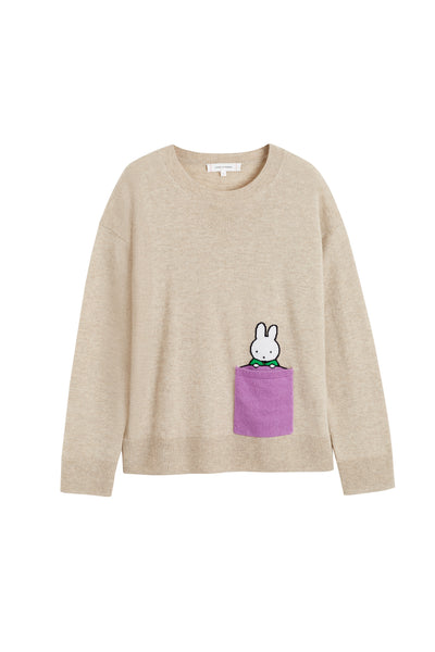 Beige sweater with a cartoon character in a pocket on a white background