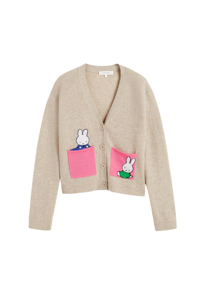 Beige cardigan with pink pockets featuring cartoon characters on a white background