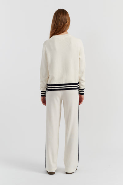 Woman wearing a white outfit with black stripes on a white background