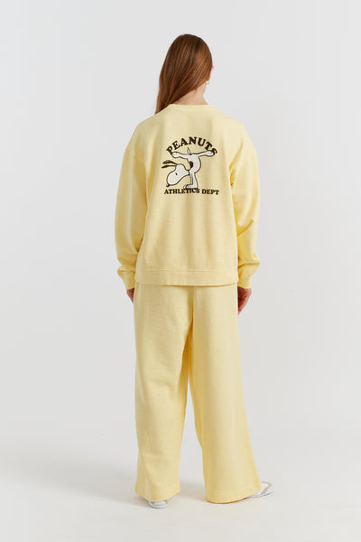 Person wearing a yellow tracksuit with a visible brand logo on the back against a white background