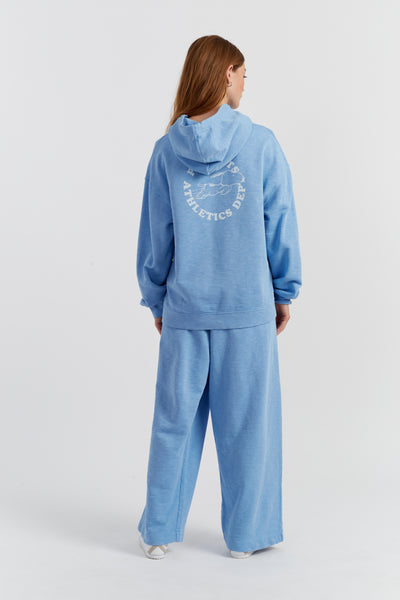 Person wearing a blue tracksuit with a logo on the back against a white background