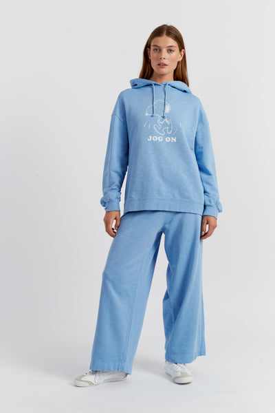 Woman wearing a blue hoodie and pants with 'Jog On' text on a white background