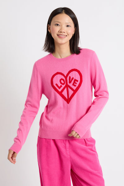 Person wearing a pink sweater with a red heart design on a white background