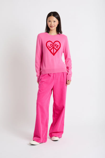 Woman wearing a pink outfit with a heart design on a white background