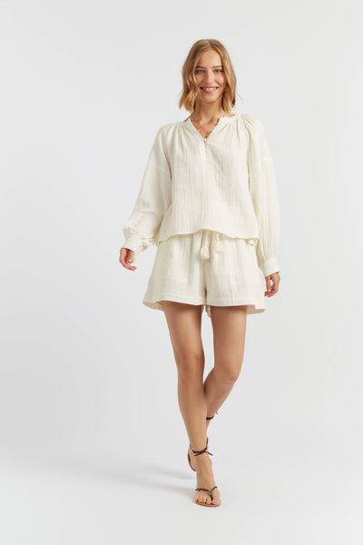 Woman wearing a cream-colored outfit on a white background