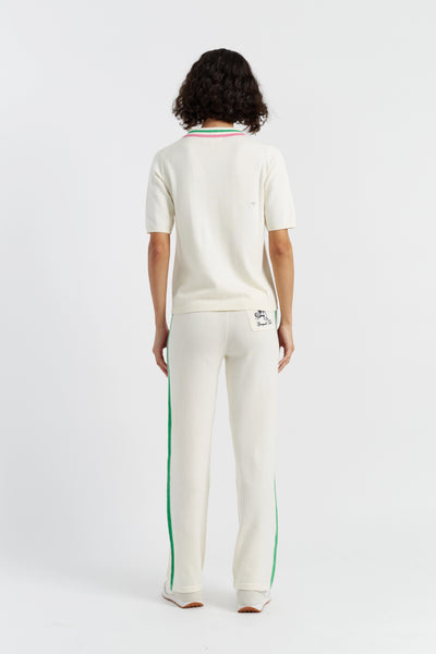 Person wearing a white outfit with green and red accents on a white background