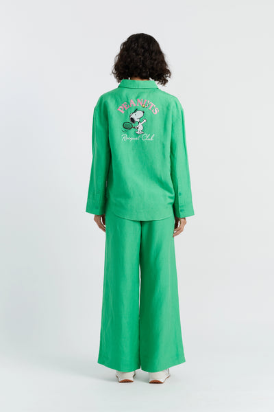 Person wearing a green outfit with a character design on the back, standing against a white background