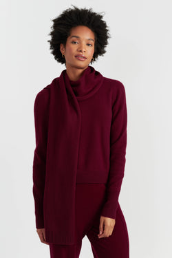 Woman wearing a burgundy outfit with a scarf on a white background
