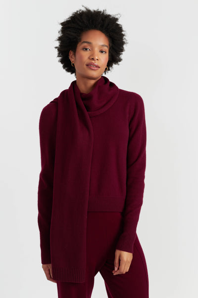 Woman wearing a burgundy outfit with a scarf on a white background