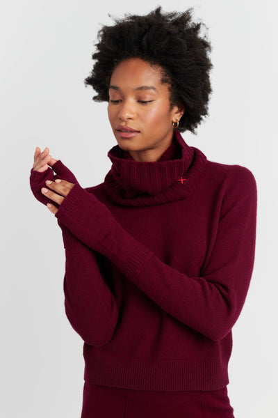 Woman wearing a burgundy sweater against a plain background