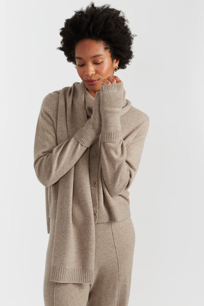 Woman wearing a beige cardigan and pants on a white background