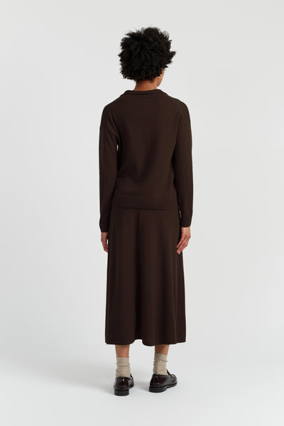 Person wearing a brown outfit on a white background