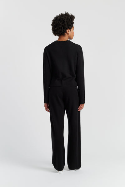 Person wearing a black outfit on a white background