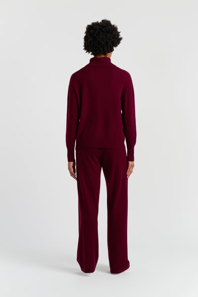 Person wearing a burgundy outfit on a white background