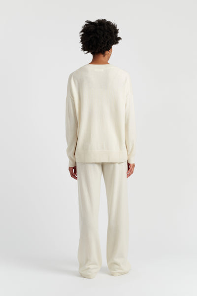 Person wearing a cream-colored outfit on a white background