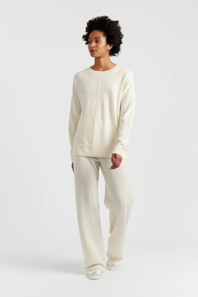 Woman wearing a cream-colored outfit on a white background