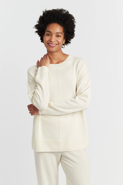 Person wearing a cream-colored outfit on a white background
