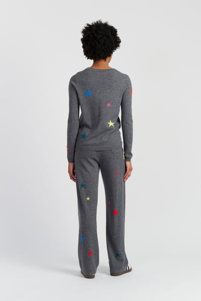 Person wearing a gray outfit with colorful star patterns on a white background