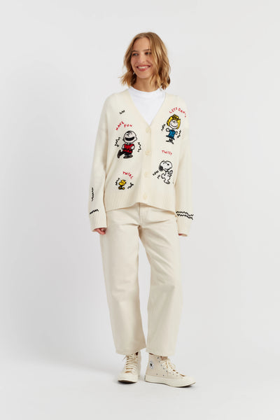 Woman wearing a cream-colored outfit with cartoon character designs on a white background