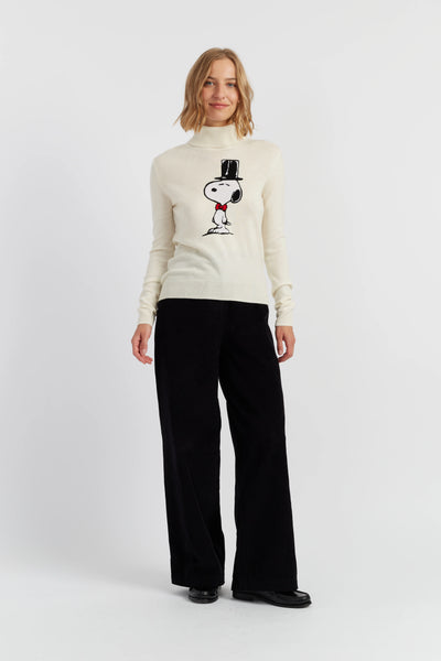 Woman wearing a white turtleneck sweater with a graphic design on a white background