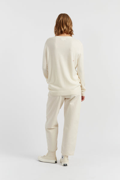 Person wearing a cream-colored outfit on a white background