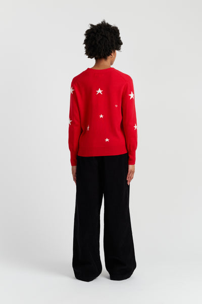Person wearing a red sweater with white stars on a white background